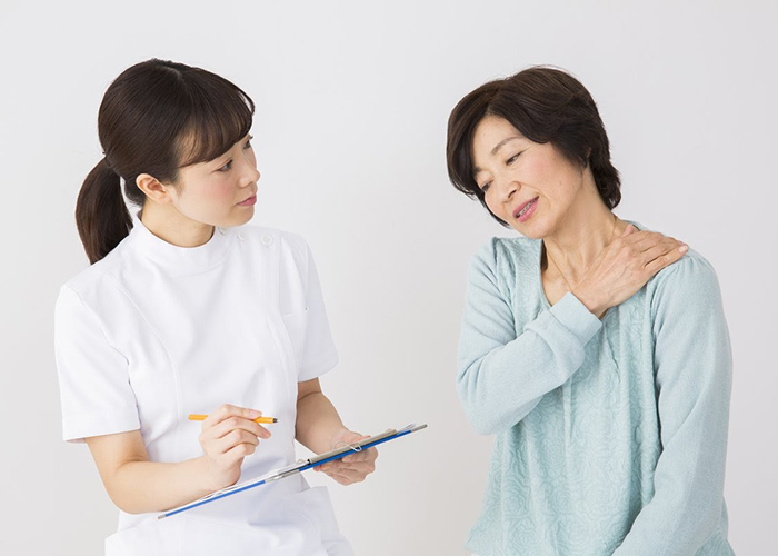 肩の不調を訴える女性と話を伺うスタッフ